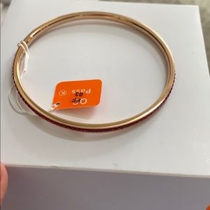 Bangle bracelet with red crystals.